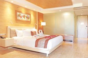 a bedroom with a large white bed in a room at de Vins Sky Hotel Seminyak in Seminyak