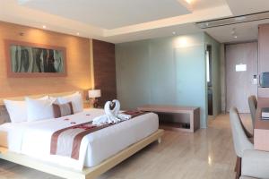 a bedroom with a large white bed in a room at de Vins Sky Hotel Seminyak in Seminyak