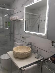 La salle de bains est pourvue d'un lavabo en pierre et d'un miroir. dans l'établissement Playa del Puntal Villaviciosa Asturias Lujo Primera Linea Playa, à Villaviciosa