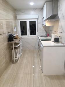 a kitchen with white appliances and a table in it at Playa del Puntal Villaviciosa Asturias Lujo Primera Linea Playa in Villaviciosa +71 photos