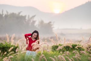 a woman standing in a field of tall grass at Phuruakeeree Resort in Loei