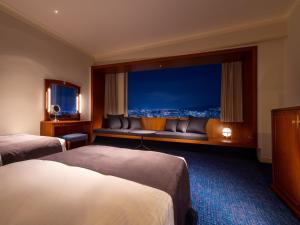 a hotel room with two beds and a television at Rihga Royal Hotel Hiroshima in Hiroshima