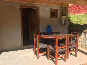 een houten tafel en stoelen voor een huis bij Cabañas Yasmina in Mazamitla