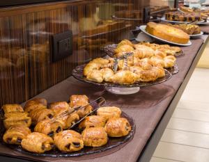 a buffet line with different types of pastries and pies at Holiday Inn Bologna - Fiera by IHG in Bologna +73 photos