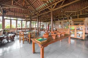- un restaurant avec une table et des casseroles dans l'établissement RedDoorz Plus @ Purwodadi, à Pasuruan