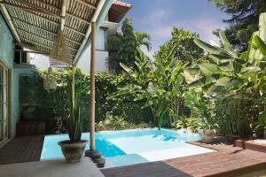 uma piscina num jardim com plantas em Villa Nido Canggu em Canggu