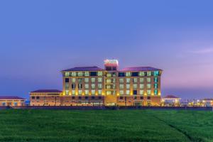 a large building with lights on in a field at Soaltee Westend Premier in Nepālganj