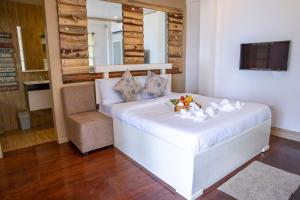 a bedroom with a white bed and a chair at Peak View Resort in San Vicente