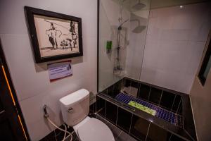a bathroom with a toilet a sink and a mirror at The Sanctuary Villa Battambang in Battambang