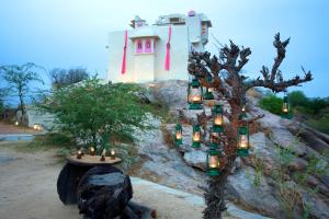 Raipur的住宿－Brij Lakshman Sagar, Pali，山丘上树上带蜡烛的房子