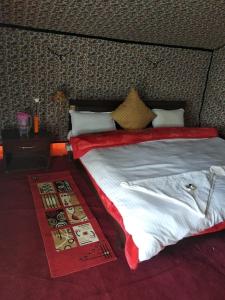 una camera da letto con un grande letto con un piumone rosso di Royal Riders Camp a Hundar