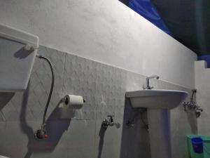 a bathroom with a sink and a toilet paper roll at Royal Riders Camp in Hundar