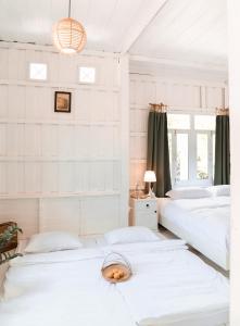 2 Betten in einem Zimmer mit weißen Wänden in der Unterkunft One Chan Farmstay in Chanthaburi