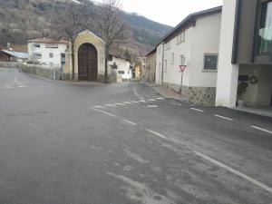 una calle vacía en un pueblo con un edificio en Ora et labora, en Malles Venosta