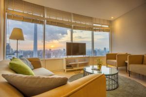 a living room with a couch and a television at Yemala Suites @ Vortex KLCC in Kuala Lumpur