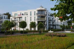 a white building with a park in front of it at Baabe Villen Ensemble FeWo 10 Balt in Baabe