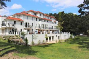 a large white house with a fence at Haus Meeresblick FeWo Wellengang 0 in Baabe