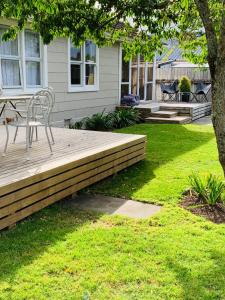 a porch with a bench and a table on a deck at Cooper's Cottage in Nelson