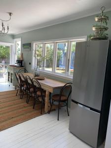 a kitchen with a table with chairs and a refrigerator at Cooper's Cottage in Nelson