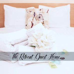 Una cama con almohadas blancas y un cartel que lee el hostal natural en The Retreat Guest House on Plymouth Hoe, en Plymouth