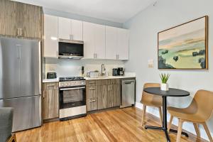 een keuken met een koelkast en een tafel en stoelen bij Magnificent 1BR Apt in Chicago - Belmont B3 in Chicago