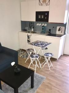 a kitchen with a table and two stools in a room at Petit studio cosy in Bobigny