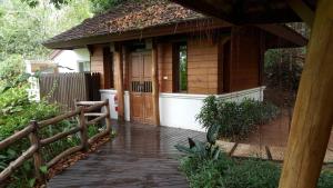 a small house with a wooden porch and a fence at Vanilla hill (hill lodge) in Ban Muang Ha