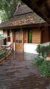 une passerelle en bois menant à une maison avec une porte en bois dans l'établissement Vanilla hill (hill lodge), à Ban Muang Ha