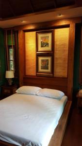 - un grand lit dans une chambre avec 2 photos sur le mur dans l'établissement Vanilla hill (hill lodge), à Ban Muang Ha