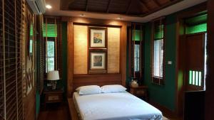 a bedroom with a bed in a room with windows at Vanilla hill (hill lodge) in Ban Muang Ha