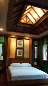 a bedroom with a large bed with a ceiling at Vanilla hill (hill lodge) in Ban Muang Ha