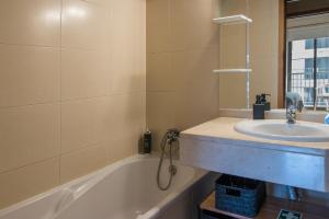 a bathroom with a sink and a bath tub at Acacia Apartment by Atlântica in Funchal +23 photos