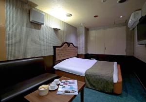 a room with a bed and a couch and a table at Hotel Mio Resort ( Adult Only) in Yokkaichi