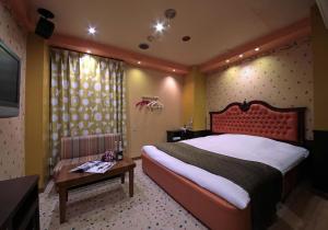 a bedroom with a large bed and a table at Hotel Mio Resort ( Adult Only) in Yokkaichi