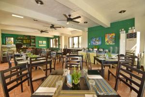 a restaurant with tables and chairs and green walls at Hotel Soffia in Boracay