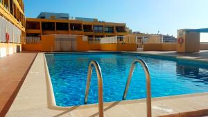 una piscina al costado de un edificio en Ocean View Playa la Arena by HelloApartments, en Puerto de Santiago