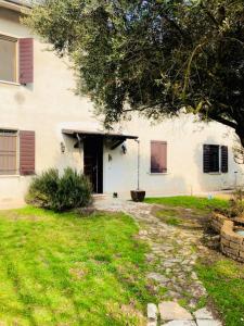 een wit huis met een tuin met een deur en gras bij B&B Villa Ermanna in Mantova