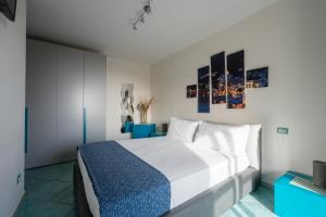 sypialnia z białym łóżkiem z niebieskimi akcentami w obiekcie Colpo d Ali - Amazing view and Jacuzzi in Ravello w mieście Ravello