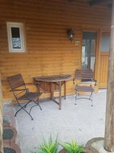 a picnic table and two chairs on a patio at Fewo Be Happy! Kleiner Bungalow mit eigener Terrasse im Grünen! in Stockhausen-Illfurth