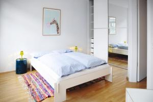 Habitación blanca con cama y espejo en Ferienwohnung Strandmuschel in Flensburg, Sonwik en Flensburg