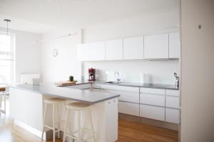 een witte keuken met witte kasten en een aanrecht bij Ferienwohnung Strandmuschel in Flensburg, Sonwik in Flensburg