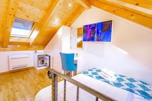 een kleine zolderslaapkamer met een bed en houten plafonds bij New Lux Villa Merissima in Split