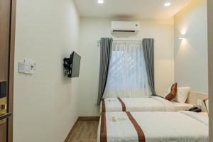 a hotel room with two beds and a window at Yurii Hotel in Phan Thiet +53 photos