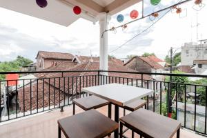 a balcony with a table and chairs and a view at Java Homestay in Yogyakarta