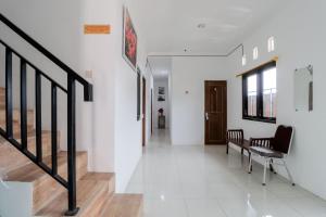 a hallway with stairs and a chair in a building at Java Homestay in Yogyakarta