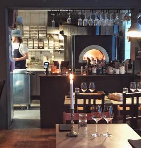 een tafel met wijnglazen en een vrouw in de keuken bij Pensionatet in Piteå