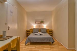 a small bedroom with a bed and a table at La Bastide d'Albignac in Le Dourn