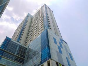 a tall building with blue glass windows at Warm and Homey 1BR Apartment at Atlanta Residences By Travelio in Pondokcina