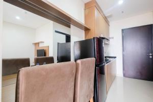 a room with chairs and a refrigerator in it at Warm and Homey 1BR Apartment at Atlanta Residences By Travelio in Pondokcina