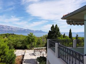 ein Balkon eines Hauses mit Blick auf das Wasser in der Unterkunft Apartman Tamara in Sumartin